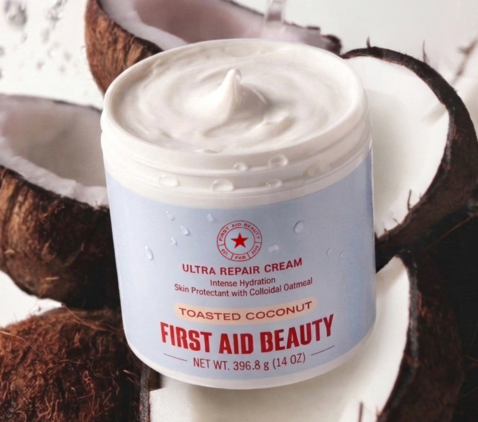 Jar of First Aid Beauty Ultra Repair Cream with toasted coconut flavor surrounded by coconuts.